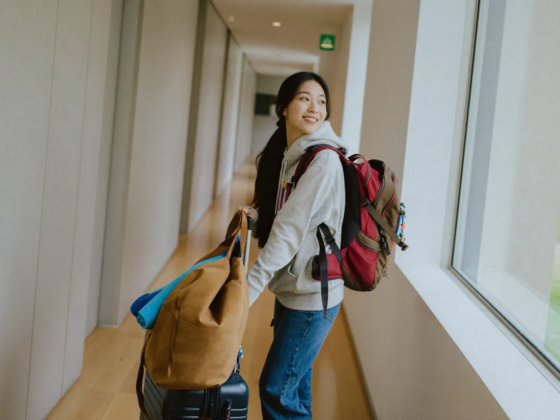 배낭을 메고 여권을 꼭 쥔 채 창밖을 바라보는 20대 대학생 — 워킹홀리데이를 앞둔 설렘과 긴장, 연출 이미지