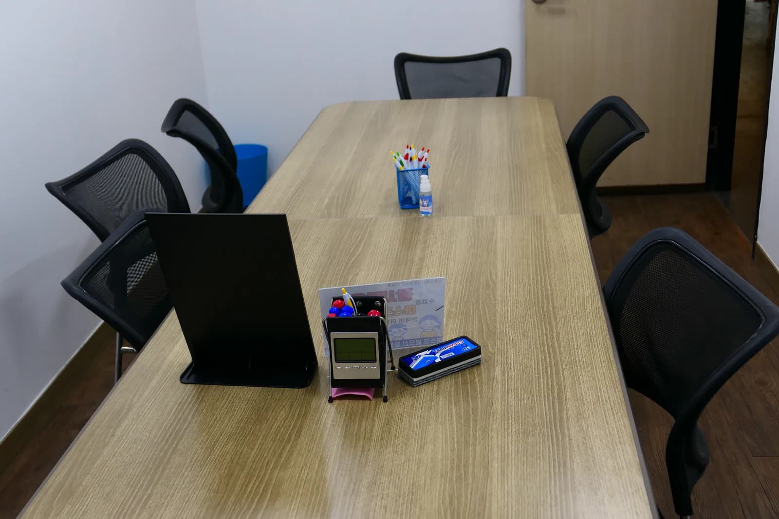 메쉬 의자와 원목 테이블이 놓인 그룹 수업용 강의실