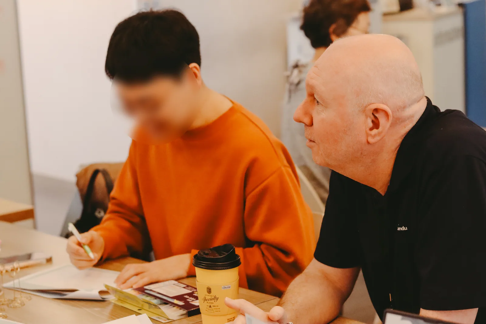필기를 하며 원어민 강사의 설명을 듣는 수강생